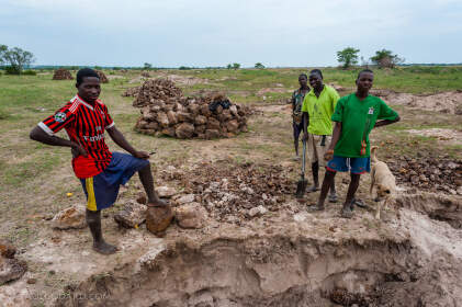 people digging stones along road