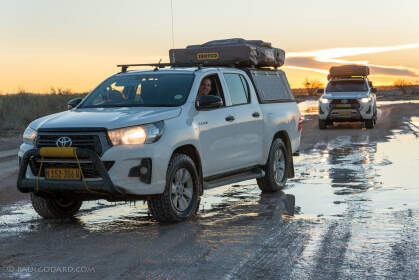 camping cars on wet road at sunset