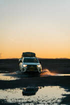camping car on wet road at sunset