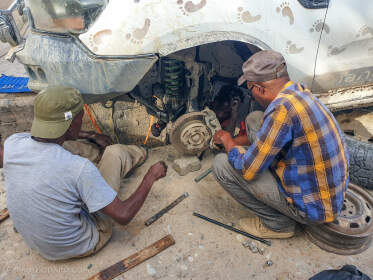 mechanics repairing ranger camper with brocken shock