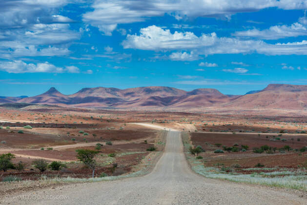 gravel road & hills under clouds