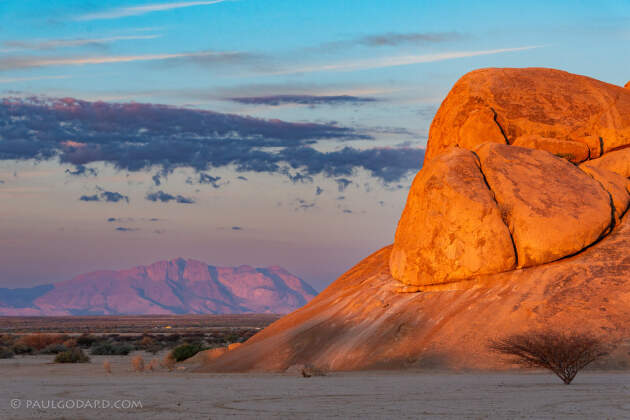 red granite rock under clouds at sunset