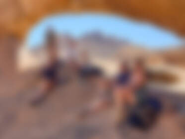 Jojo, Julien, Manon, Marc, Marie, Mathou & Simon sitting under natural arch