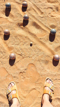 Marie's feet next to petanque balls