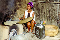 girl cooking ingera at fire place