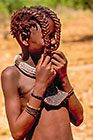 Himba boy playing w horse tail hair