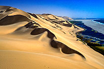 sand dunes + coast line + waves in sea