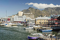 boats in waterfront harbour + old buildings + table mt + clouds