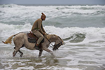 Guide Malu riding horse in waves