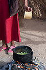 old busman woman preparing nama melon soup in open kitchen