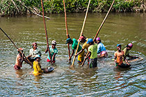 people panning sand for gold in river