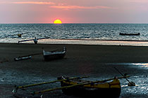 pirogues on beach at sunset