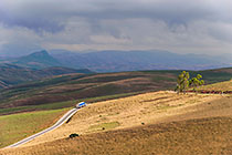 truck driving on road through hills
