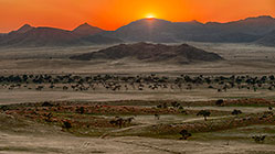 grass plain & mountains at sunrise