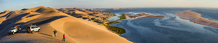 Simons near Land Cruiser on sand dune | Sandwish Harbour lagoon