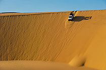 Land Cruiser driving down sand dunes