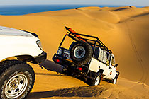 Land Cruiser driving down sand dunes