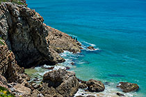 people fishing along rocky seashore