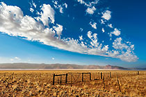 fence in desert | clouds