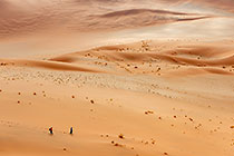 Enya & James walking on sand dunes under clouds