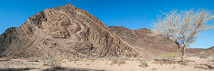 geological folds along riverbed mountains
