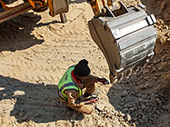 worker replacing teeth on digger loader