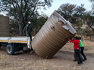 workers off loading 10000 l water tank from truck