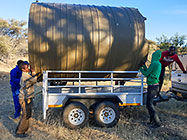 workers loading 10000 l water tank on trailer