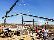 workers & crane truck erecting workshop steel portal