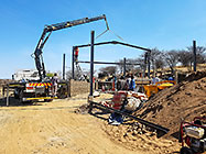 workers & crane truck erecting workshop steel portal