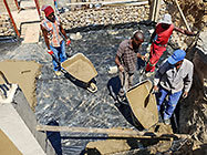 workers pooring concrete slab in gabion room