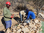 worker filling top gabion baskets with stones before suspended slab
