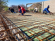 workers tiding steel bars on studio suspended slab over gabion room