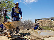 workers pooring concrete on studio suspended slab over gabion room