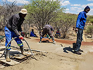 workers pooring concrete on studio suspended slab over gabion room