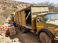 team with grader rescuing 4x4 truck broken down on plot access road