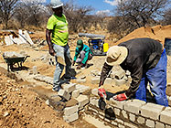 Licius workers building workshop foundation walls