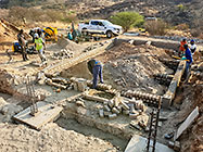 Licius workers building workshop foundation walls