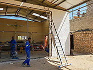 Donald & Sedney welding steel frame for workshop doors