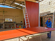 Sedney rivetting roof sheet on workshop door steel frame