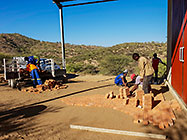 Bernard workers paving bricks in front of workshop