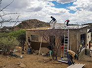 Licius workers plastering studio walls & Donald installing roof sheets