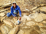Donald cleaning stones on studio pathways