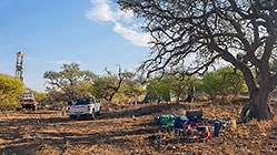 Human truck & bakkie drilling borehole in riverbed