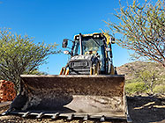 digger loader excavating trenches for house foundation