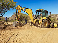 Donald & Sedney watching digger loader excavating trenches for house foundation