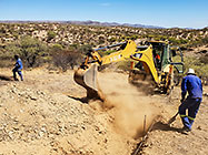 Donald & Sedney watching digger loader excavating trenches for house foundation