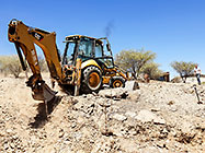 Lisa watching digger loader excavating trenches for house foundation