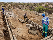 Bernard workers building house foundation walls