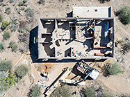 aerial view of 4x4 Unimog with crane installing house roof wooden beams